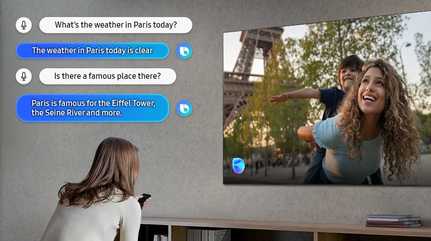 Woman in the living room speaks to Bixby through her OLED TV. Captions of the dialogue are shown. What’s the weather in Paris today? The weather in Paris today is clear. Is there a famous place there? Paris is famous for the Eiffel Tower, the Seine River and more.