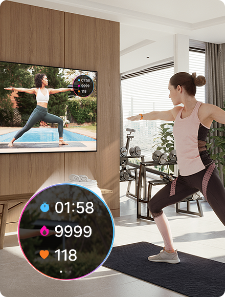 Người phụ nữ tập yoga trong khi xem huấn luyện viên trên TV. TV cũng hiển thị số liệu thống kê bài tập 01:58, 9999, từ Galaxy Watch.